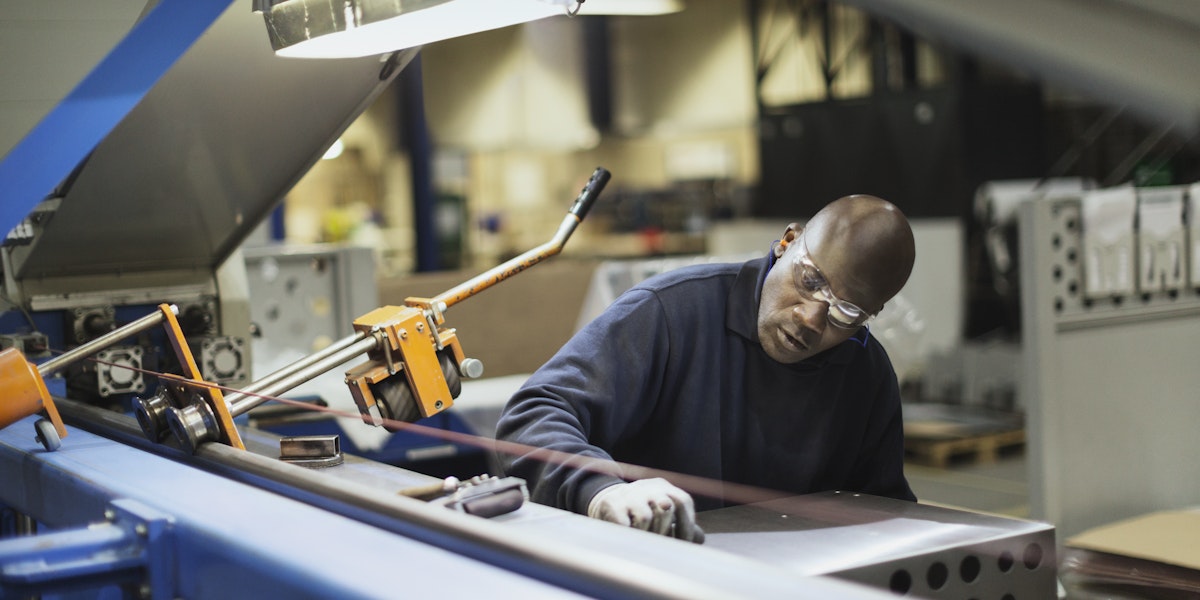 Worker operating machinery in steel factory
