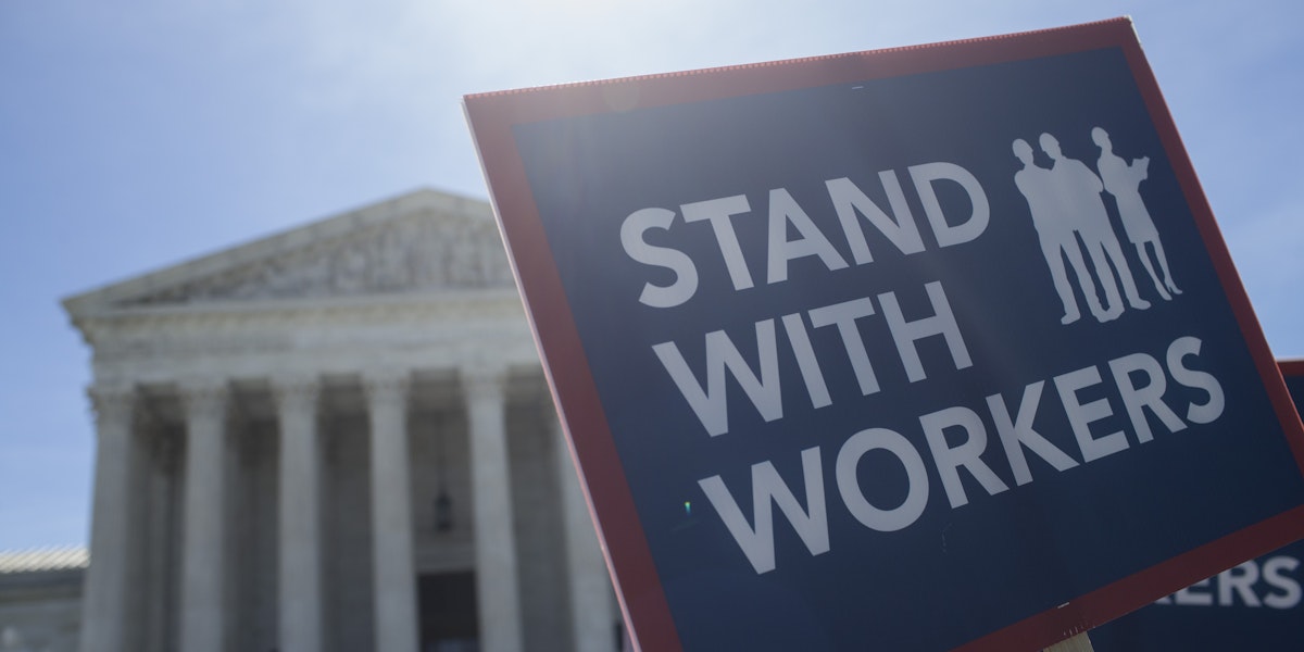 WASHINGTON, DC - JUNE 25: A demonstrator holds a sign in front of the U.S. Supreme Court on June 25, 2018 in Washington, DC. The high court is expected to issue decisions in six remaining cases, including the travel ban, public sector unions and redistricting, ahead of their end-of-June deadline this week.  (Photo by Zach Gibson/Getty Images)