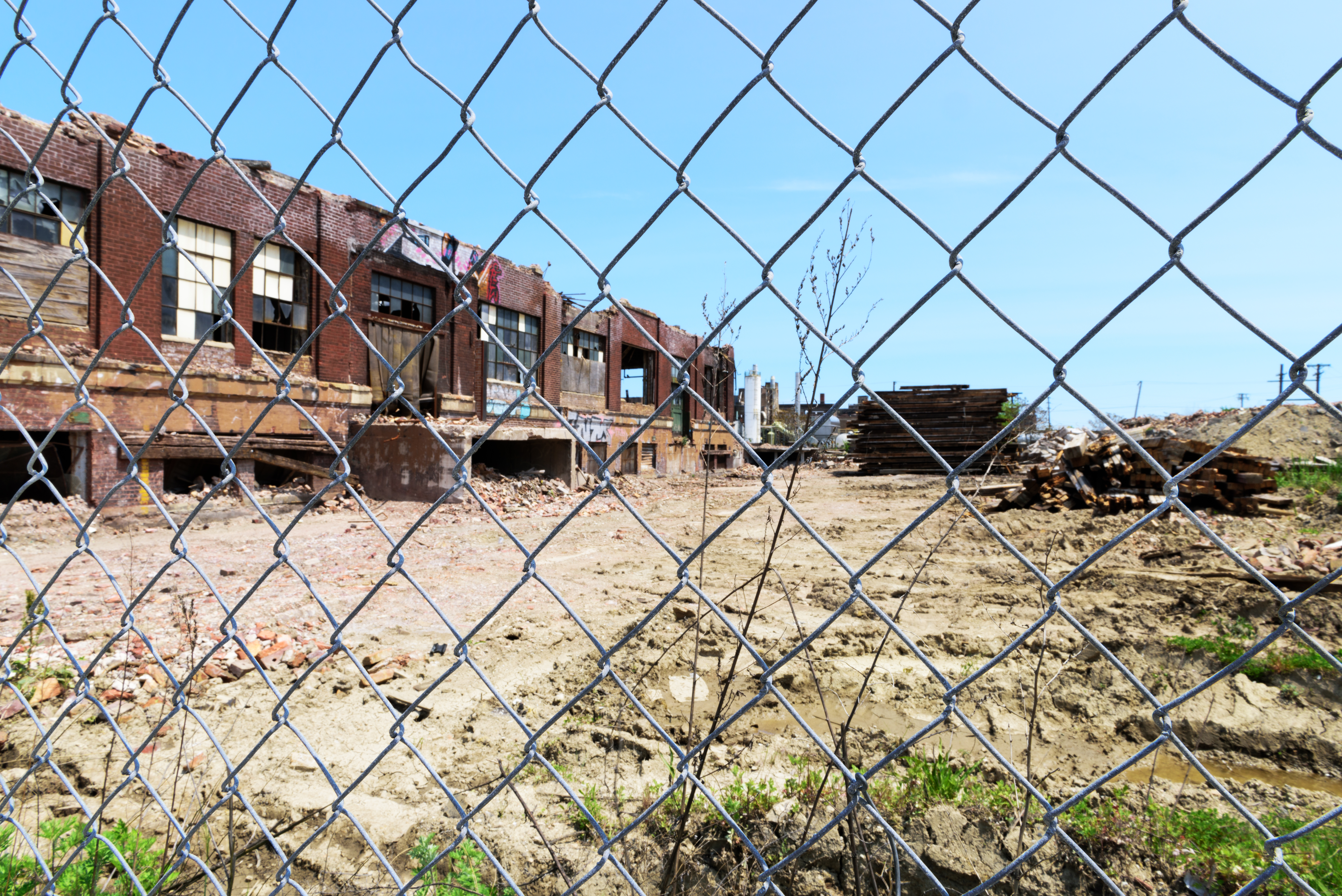 Chicago, USA - May 21, 2016: Derelict Chicago industrial building, half demolished,  viewed through a chainlink fence. McKinley Park community area, Southwest Side. No people.
