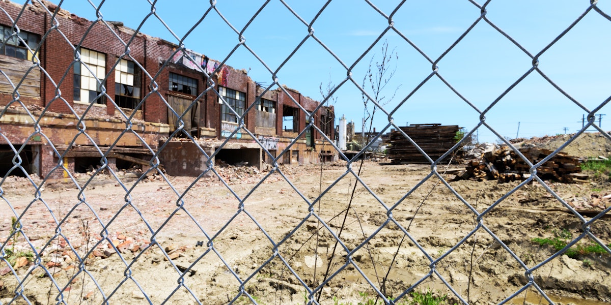 Chicago, USA - May 21, 2016: Derelict Chicago industrial building, half demolished,  viewed through a chainlink fence. McKinley Park community area, Southwest Side. No people.