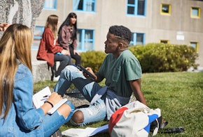 young adults sitting on grass