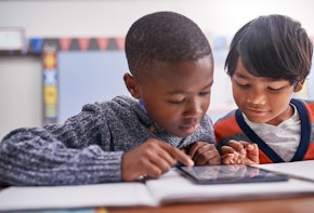 Cropped shot of elementary school children using a tablet in class