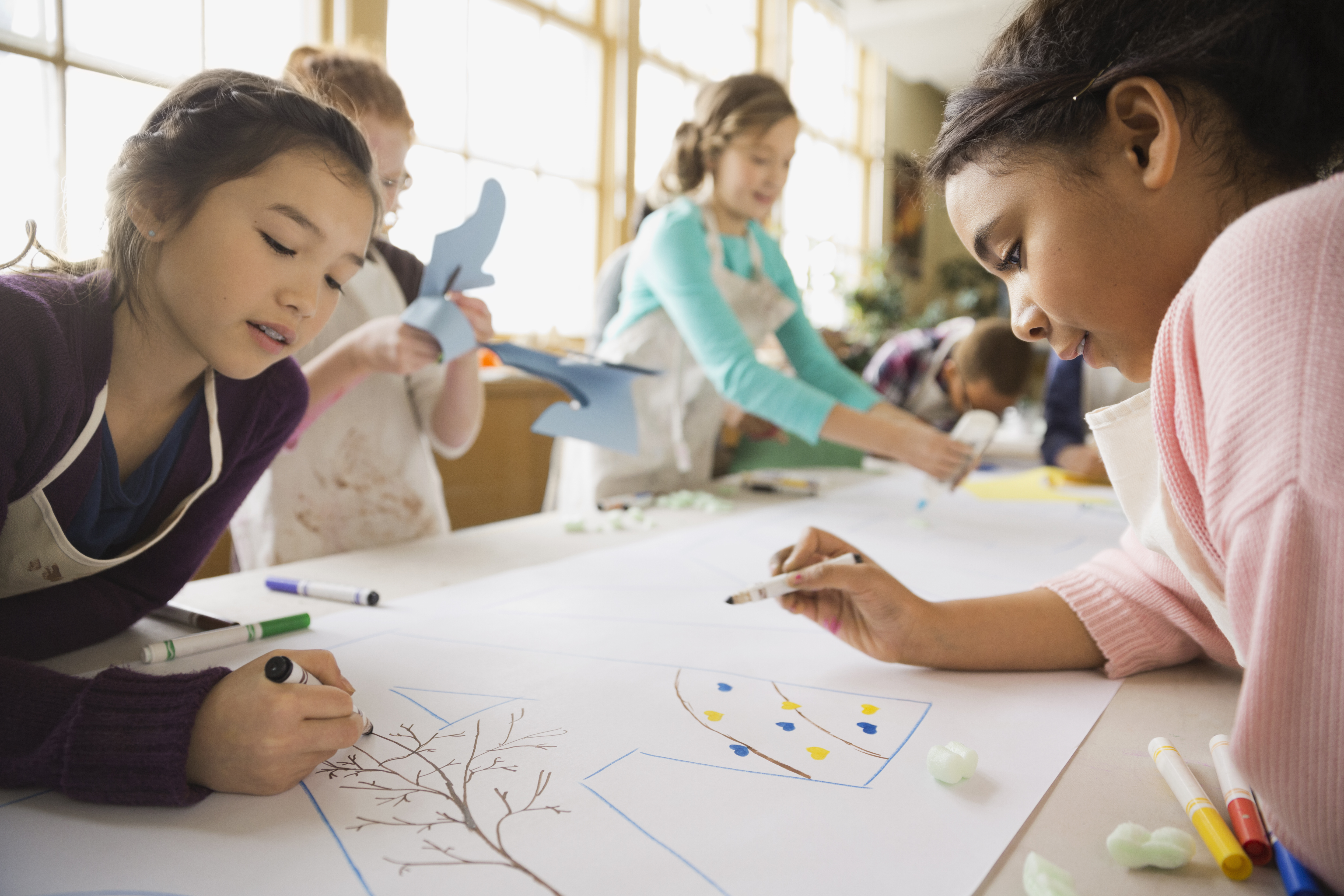 Children drawing on a large poster