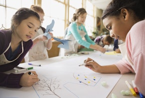 Children drawing on a large poster