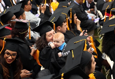 NEW YORK, NY - JUNE 03:  A graduating student holds her child as she participates in commencement exercises at City College where First lady Michelle Obama delivered the commencement speech after being presented with an honorary doctorate of humane letters at City College on June 3, 2016 in New York City. This is the final  commencement speech of her tenure as first lady. In her speech Mrs. Obama celebrated City College's diverse student body and the struggles that many students endured on the road to graduation.  (Photo by Spencer Platt/Getty Images)