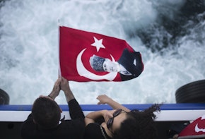 a couple of people holding a flag on top of a boat