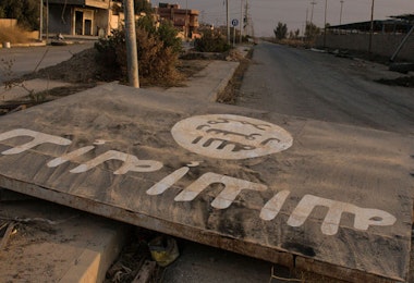 An ISIL billboard is seen destroyed in the middle of the road in Qaraqosh, Iraq.