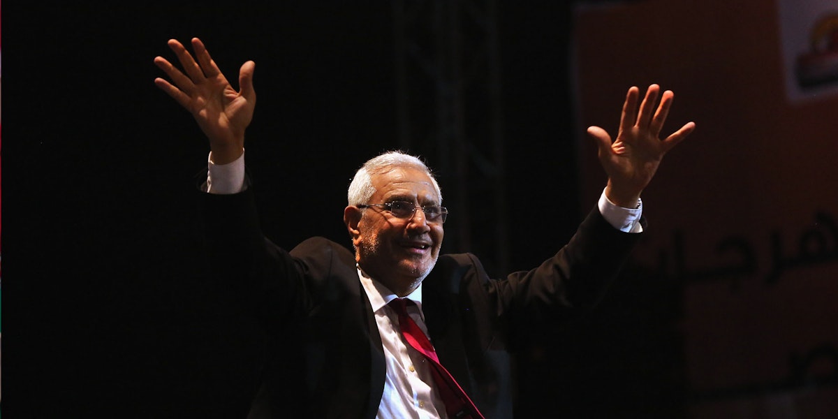 a man in a suit and tie raising his hands