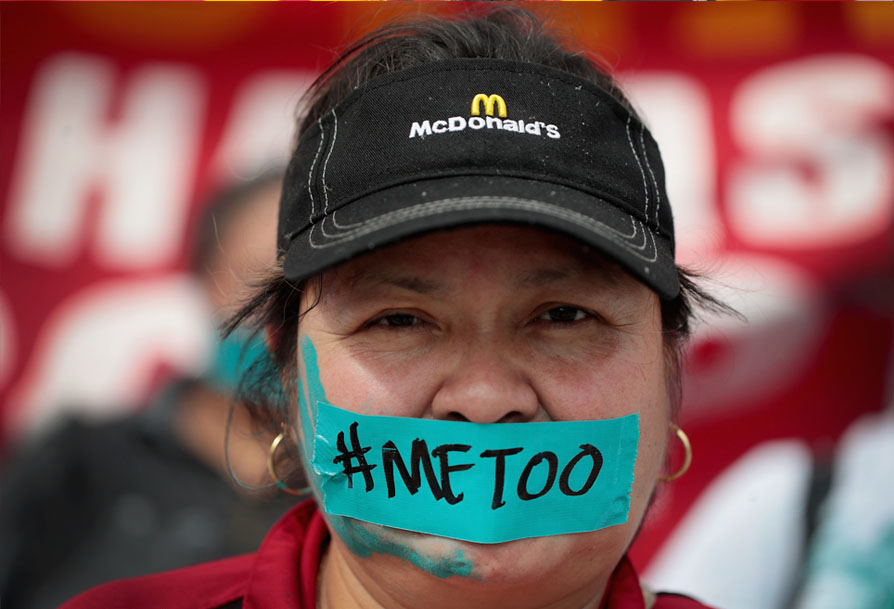 An McDonalds employee with tape over her mouth with the writing #METOO