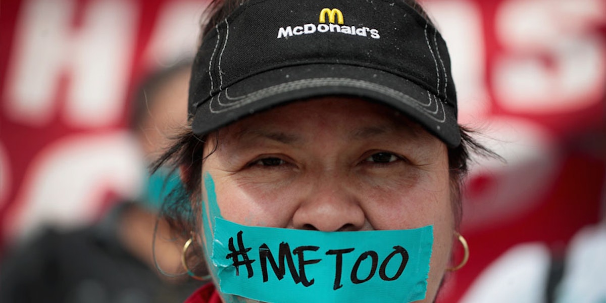 An McDonalds employee with tape over her mouth with the writing #METOO
