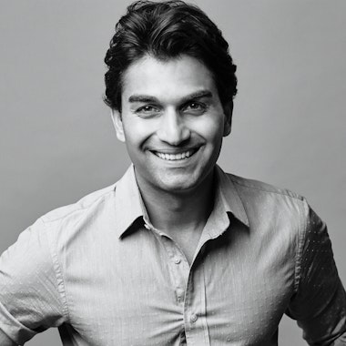 A black and white photo of a man smiling