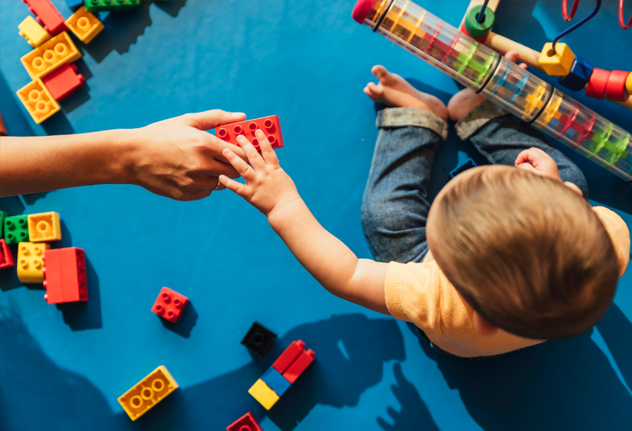 A photograph of a todler playing with legos