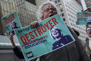 A demonstrator holding a poster saying Betsy the Destroyer of Education