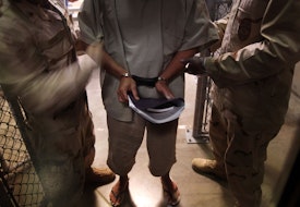 GUANTANAMO BAY, CUBA - MARCH 30:  (EDITORS NOTE: Image has been reviewed by the U.S. Military prior to transmission.) U.S. Navy guards escort a detainee after a