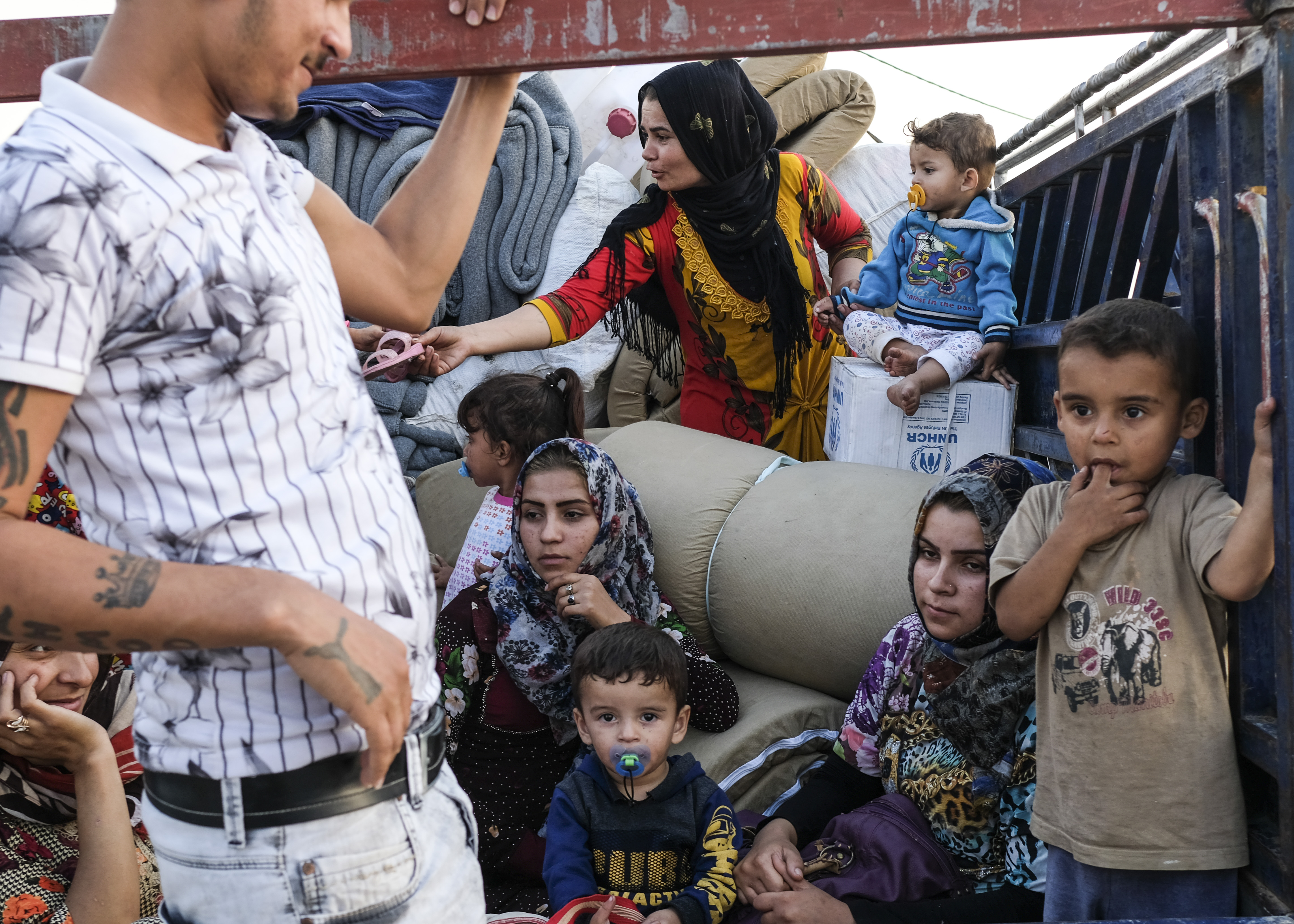 DOHUK, IRAQ - OCTOBER 24: A family from Qamishli, Syria arrives at Badarash IDPs camp which has continued to swell for Syrian Kurdish refugees fleeing the recent Turkish incursion in Rojava. on October 24, 2019 in Dohuk, Iraq. In seven days UNHCR reports that 7,100 have now arrived to the camp.  Many fleeing have said saying they paid to be smuggled through the Syrian border.  (Photo by Byron Smith/Getty Images)