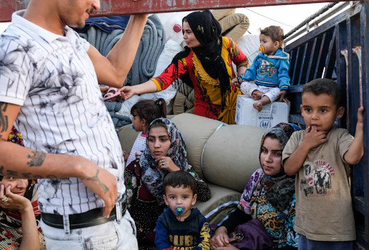 DOHUK, IRAQ - OCTOBER 24: A family from Qamishli, Syria arrives at Badarash IDPs camp which has continued to swell for Syrian Kurdish refugees fleeing the recent Turkish incursion in Rojava. on October 24, 2019 in Dohuk, Iraq. In seven days UNHCR reports that 7,100 have now arrived to the camp. Many fleeing have said saying they paid to be smuggled through the Syrian border. (Photo by Byron Smith/Getty Images)