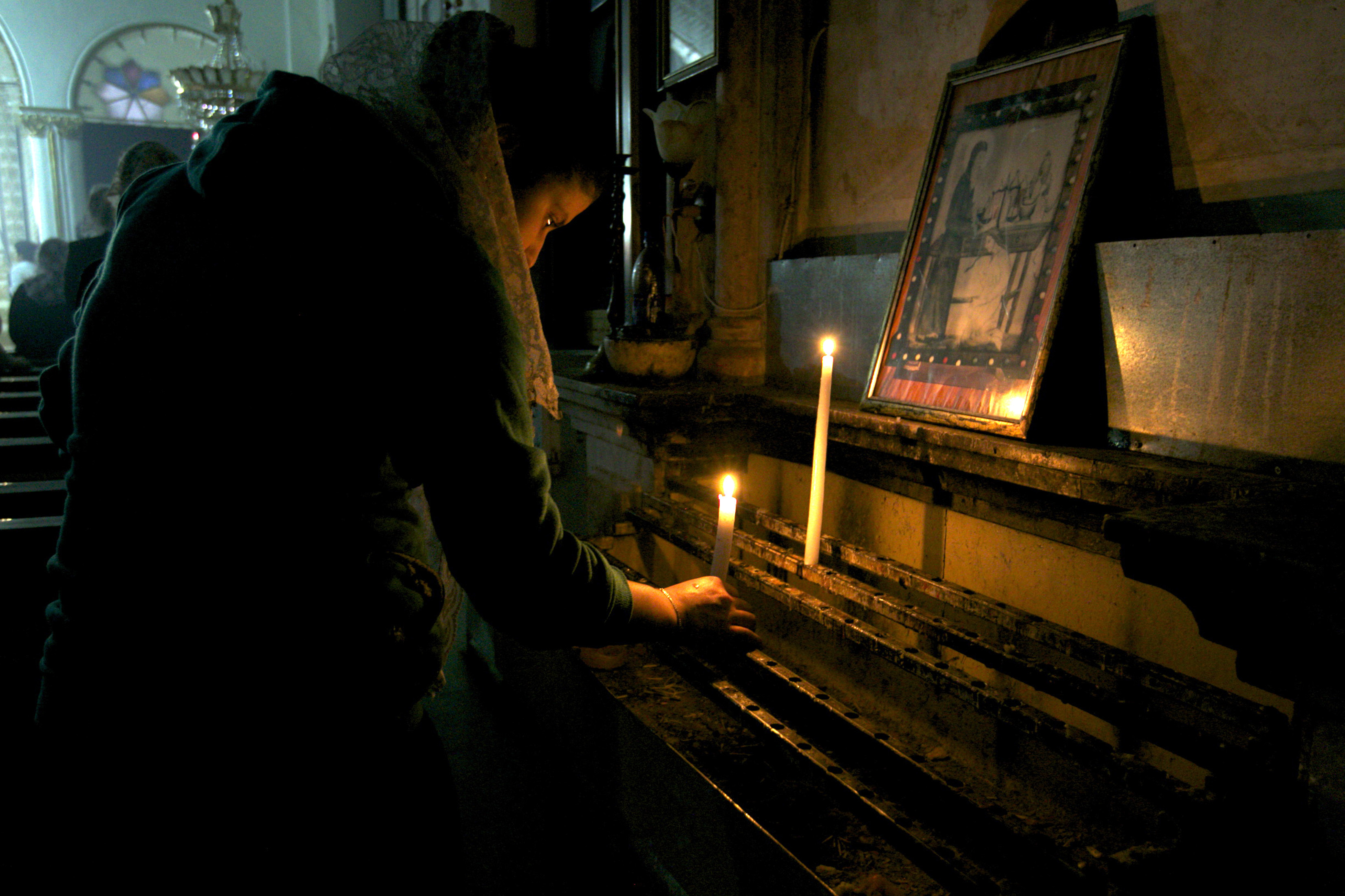 A worshipper lights a candle at the Syriac Orthodox Church in Al-Darbasiyah, Hasakah province November 13, 2013. Due to the clashes in north-eastern Syria, many Christians have fled the area seeking safety elsewhere, activists say. Picture taken November 13, 2013.  REUTERS/Stringer (SYRIA - Tags: CONFLICT RELIGION CIVIL UNREST) - GM1E9BF1K1001
