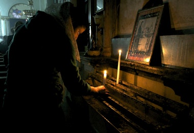 A worshipper lights a candle at the Syriac Orthodox Church in Al-Darbasiyah, Hasakah province November 13, 2013. Due to the clashes in north-eastern Syria, many Christians have fled the area seeking safety elsewhere, activists say. Picture taken November 13, 2013.  REUTERS/Stringer (SYRIA - Tags: CONFLICT RELIGION CIVIL UNREST) - GM1E9BF1K1001
