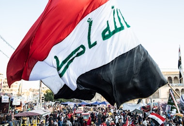 BAGHDAD, IRAQ - NOVEMBER 21: A flag waves over Tahrir Square on November 21, 2019 in Baghdad, Iraq. Thousands of demonstrators have occupied Baghdad's center Tahrir Square since October 1, calling for government and policy reform. For many, Tahrir Square, which protesters are calling 