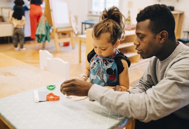 a man and a little girl sitting at a table