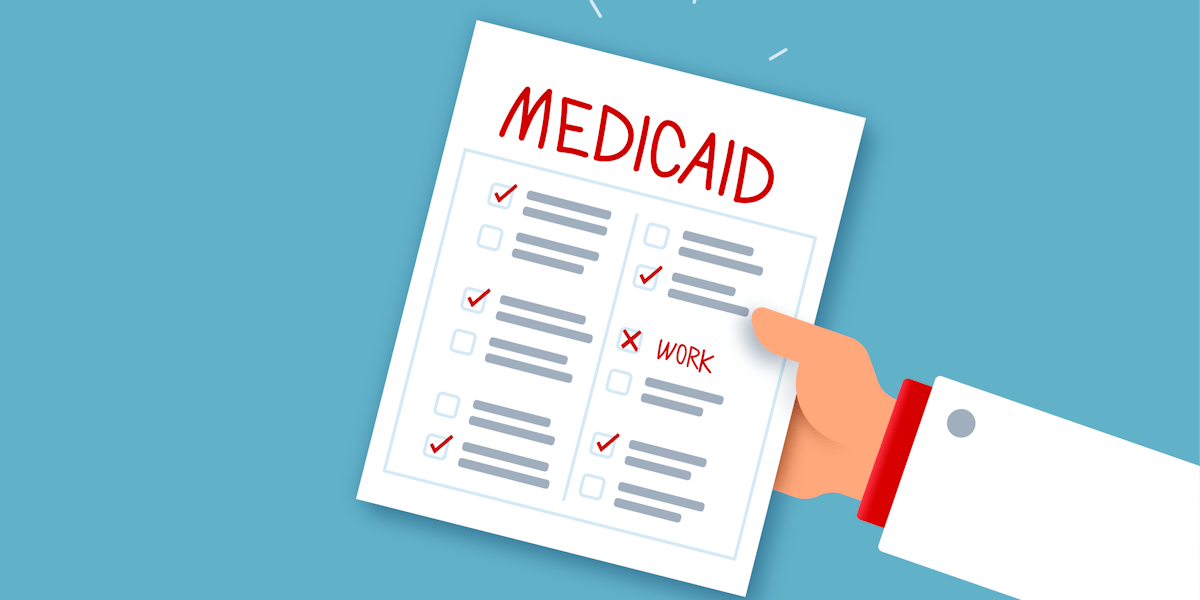 a hand holding a piece of paper with the word medicaid on it