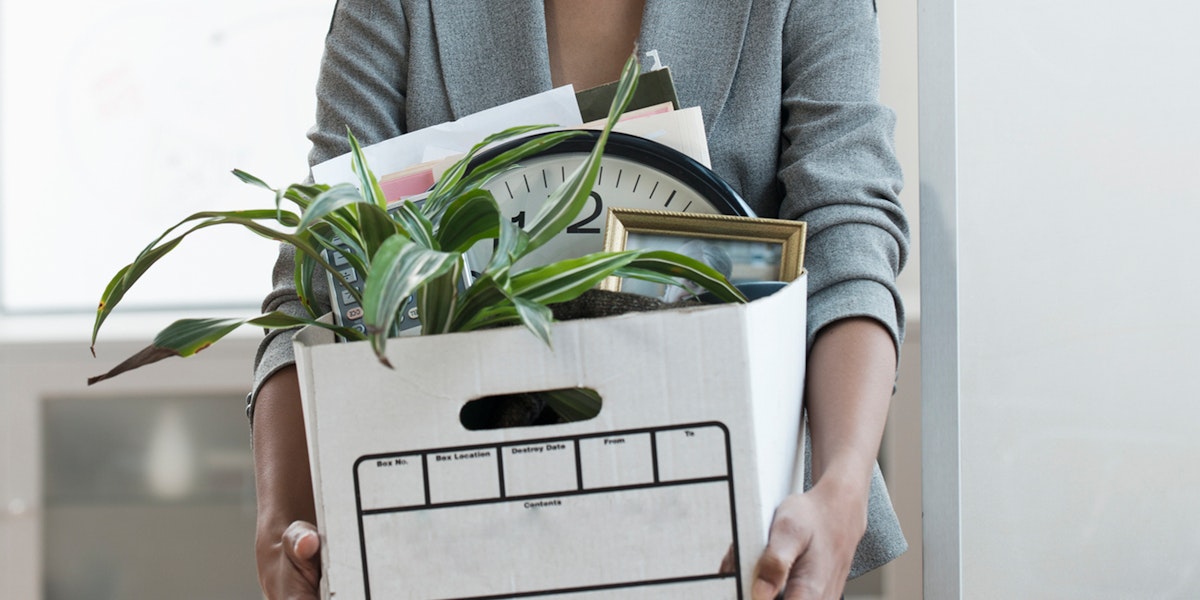 a woman holding a box with a plant in it