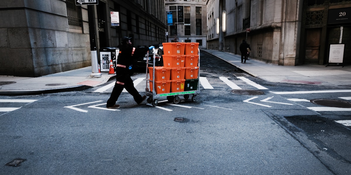 NEW YORK CITY,  - MARCH 24:  A man makes deliveries near Wall Street as people stay away from the area due to the coronavirus on March 24, 2020 in New York City. Across the country schools, businesses and places of work have either been shut down or are restricting hours of operation as health officials try to slow the spread of COVID-19.  (Photo by Spencer Platt/Getty Images)