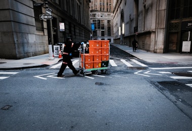 NEW YORK CITY, - MARCH 24: A man makes deliveries near Wall Street as people stay away from the area due to the coronavirus on March 24, 2020 in New York City. Across the country schools, businesses and places of work have either been shut down or are restricting hours of operation as health officials try to slow the spread of COVID-19. (Photo by Spencer Platt/Getty Images)