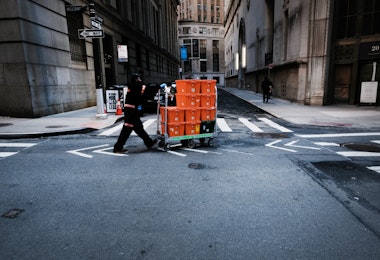 NEW YORK CITY,  - MARCH 24:  A man makes deliveries near Wall Street as people stay away from the area due to the coronavirus on March 24, 2020 in New York City. Across the country schools, businesses and places of work have either been shut down or are restricting hours of operation as health officials try to slow the spread of COVID-19.  (Photo by Spencer Platt/Getty Images)