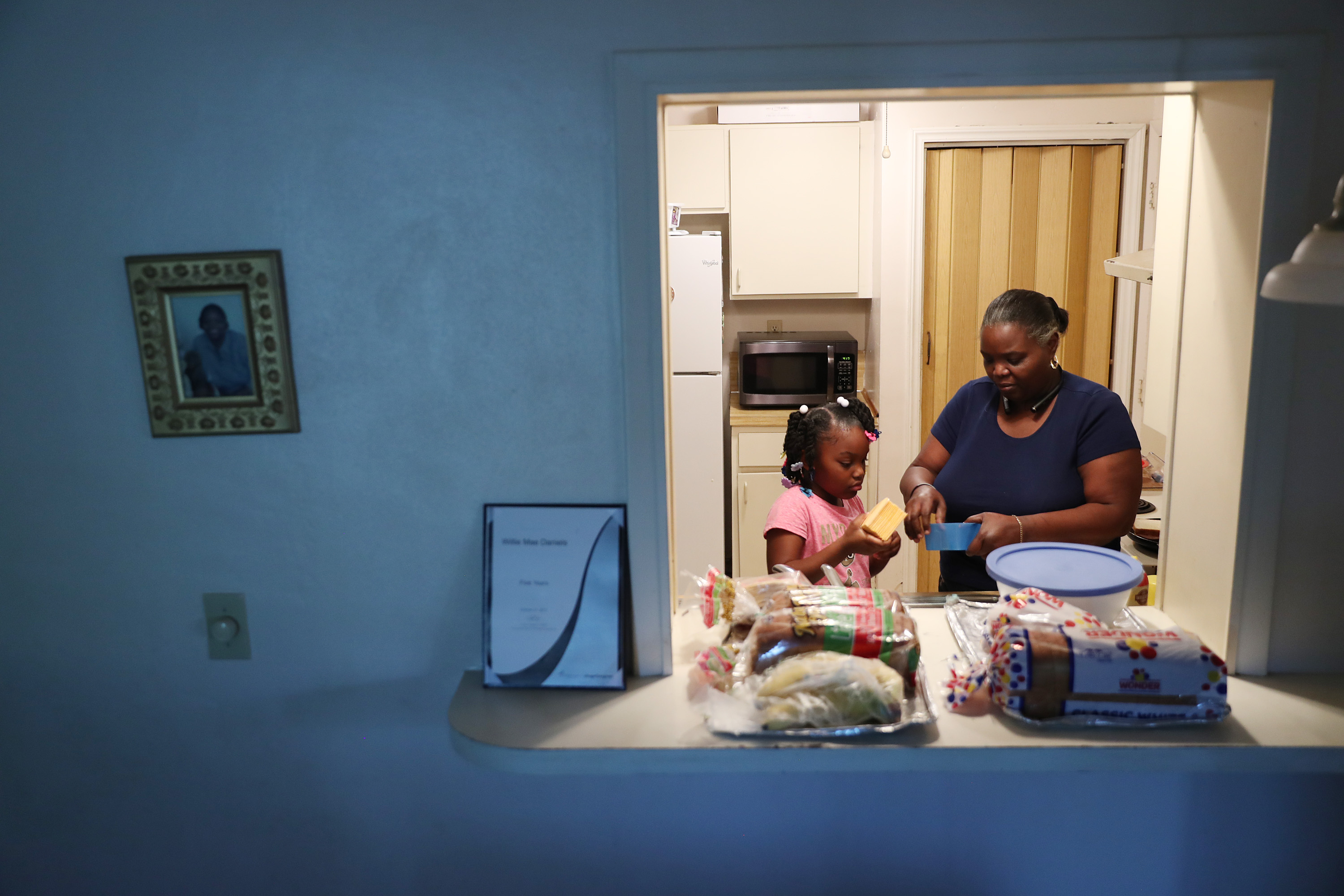 MIAMI, FLORIDA - MARCH 26: Willie Mae Daniels makes melted cheese sandwiches with her granddaughter, Karyah Davis,6, after being laid off from her job as a food service cashier at the University of Miami on March 17 as the university joins in the effort to fight the coronavirus on March 26, 2020 in Miami, Florida. Mrs. Daniels said that she has applied for unemployment benefits as she joins roughly 3.3 million Americans nationwide who are looking for unemployment benefits as restaurants, hotels, universities, stores and more shut down in an effort to slow the spread of COVID-19. (Photo by Joe Raedle/Getty Images)