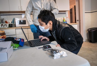 STAMFORD, CONNECTICUT - APRIL 18: (EDITORIAL USE ONLY) Recovering from COVID-19, Guatemalan immigrant Junior, 7, tries to log-in to his school ChromeBook on April 18, 2020 in Stamford, Connecticut. He and his father Marvin have been sick and in quarantine at home for several weeks. His mother, Zully, a Guatemalan asylum seeker also sick with COVID-19, gave birth to baby boy named Neysel by emergency C-section at Stamford Hospital. Junior's Bilingual /ESL teacher Luciana Lira at Hart Magnet Elementary in Stamford, became temporary guardian for the newborn, while the family recovers. Lira continues remote teaching her elementary school students, while also caring for the infant at home. She plans to continue doing so until the Guatemalan family all test negative for the virus and can care for the child themselves. (Photo by John Moore/Getty Images)