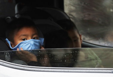 VAN NUYS, CALIFORNIA - APRIL 09: A boy wears a face mask as food is delivered to his truck at a Food Bank distribution for those in need as the coronavirus pandemic continues on April 9, 2020 in Van Nuys, California. Organizers said they had distributed food for 1,500 families amid the spread of COVID-19.  (Photo by Mario Tama/Getty Images)