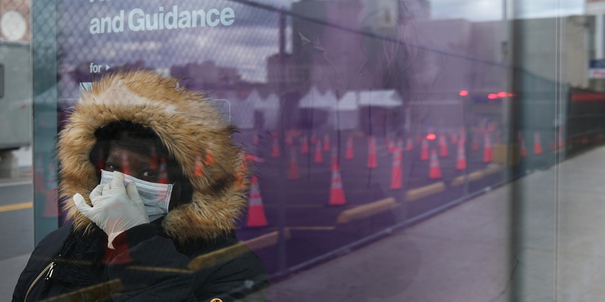 NEW YORK, NY - APRIL 10: A woman waits for a bus near a coronavirus testing site in Brooklyn on April 10, 2020 in the Brooklyn borough of New York City. According to John Hopkins University, the global death toll from COVID-19 has now reached 100,000 worldwide with many experts believing that the number is actually higher.   (Photo by Spencer Platt/Getty Images)