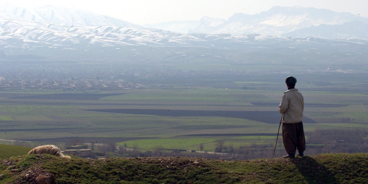 HALABJA, IRAQ - FEBRUARY 24:  A shepherd stands looking out towards the mountains where a mass grave site of most of the victims of the March 16, 1988 chemical attacks on Halabja are buried February 24, 2004 in Halabja, Iraq. In Halabja, approximately 5,000 innocent civilians, mostly women and children (75 percent), immediately perished due to chemical attacks committed allegedly by the Iraqi regime. The chemical attacks were said to have involved mustard gas, nerve agents and possibly cyanide. The attack on Halabja took place amidst the infamous al-Anfal campaign, in which former Iraqi Dictator Saddam Hussein is alleged to have brutally repressed yet another of the Kurdish revolts during the Iran-Iraq war at the time.  (Photo by Marco Di Lauro/Getty Images)