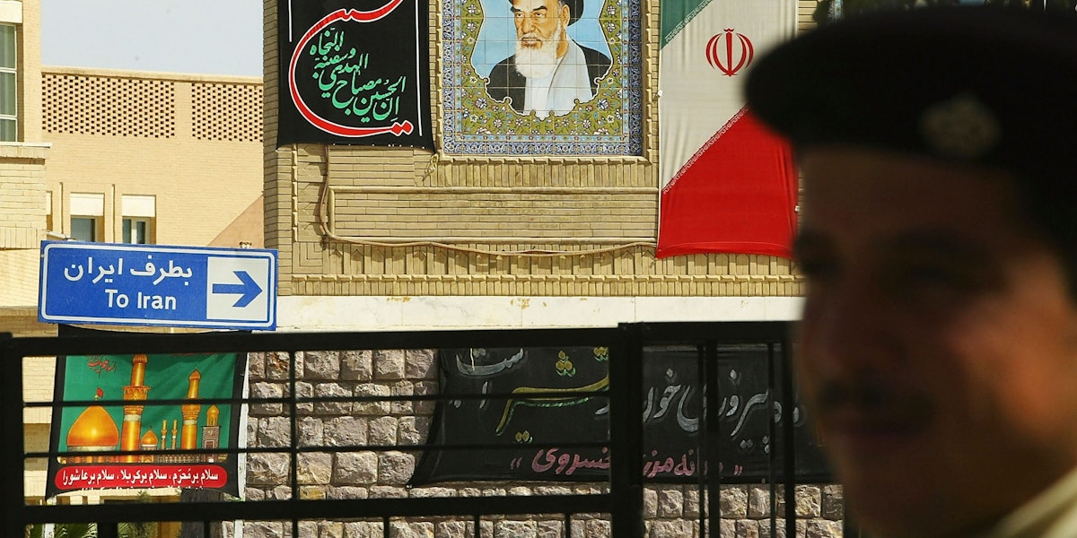AL-MUNTHRIYA, IRAQ - MARCH 15:  An Iraqi border guard stands in front of a picture of the late Iranian leader Ayatollah Khomeini, which is displayed on the Iranian side March 15, 2004 at the Al-Munthriya border crossing in Al-Munthriya, Iraq.  The US has begun tightening security over Iraq's 1,300km border with Iran over the weekend, as six more US servicemen were killed in attacks by forces opposed to the 11-month old occupation. Currently there are 19 legal crossing points between Iraq and Iran, but this will be reduced to three and each traveler will have to produce a passport and be registered, Paul Bremer, the senior US administrator in Iraq, announced Saturday. The number of Iraqi border guards are to be doubled to 16,000.  (Photo by Spencer Platt/Getty Images)