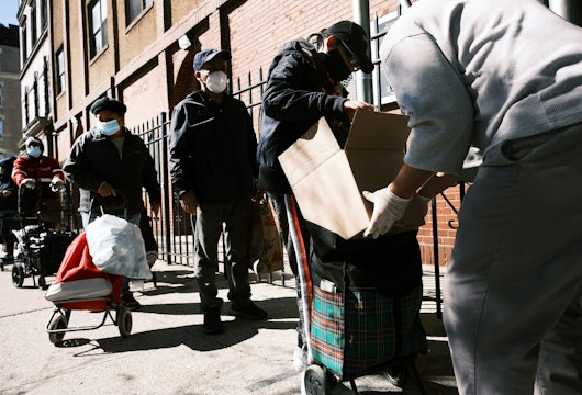 NEW YORK, NEW YORK - OCTOBER 17: People receive food at the Thessalonica Christian Church during a distribution on October 17, 2020 in New York City. The Bronx, a borough which has long struggled with poverty and neglect, has been especially impacted by the COVID-19 pandemic. The official unemployment rate in the Bronx is 21% while the unofficial number is presumed to be almost twice that. With many residents unable to afford health care and being home to a significant amount of front-line workers, the Bronx has the highest COVID-19 death rate in New York City. (Photo by Spencer Platt/Getty Images)