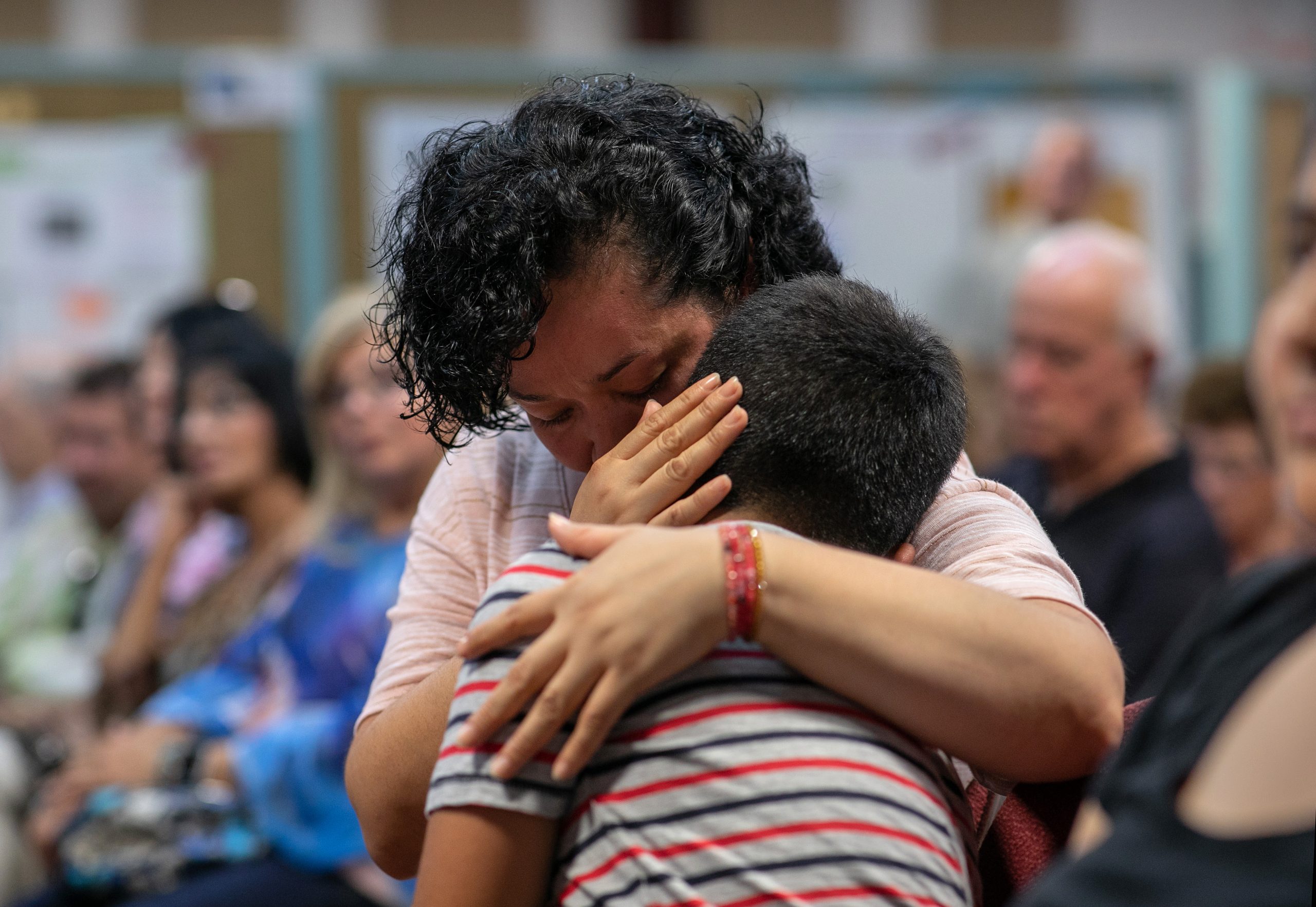 STAMFORD, CONNECTICUT - AUGUST 12: A Mexican immigrant embraces her son at town hall-style event held to reassure the nervous local immigrant community on August 12, 2019 in Stamford, Connecticut. State and local government leaders listened as immigrants spoke of their fears in an atmosphere of racially-charged tweets from President Trump and following the El Paso mass shooting, which targeted people of Mexican heritage. Officials reassured them they would continue to receive support in the state Connecticut, even as the federal government pursues the President's anti-immigrant agenda. The event was held at the Building One Community immigrant center in Stamford.  (Photo by John Moore/Getty Images)
