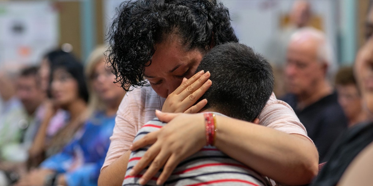 STAMFORD, CONNECTICUT - AUGUST 12: A Mexican immigrant embraces her son at town hall-style event held to reassure the nervous local immigrant community on August 12, 2019 in Stamford, Connecticut. State and local government leaders listened as immigrants spoke of their fears in an atmosphere of racially-charged tweets from President Trump and following the El Paso mass shooting, which targeted people of Mexican heritage. Officials reassured them they would continue to receive support in the state Connecticut, even as the federal government pursues the President's anti-immigrant agenda. The event was held at the Building One Community immigrant center in Stamford.  (Photo by John Moore/Getty Images)