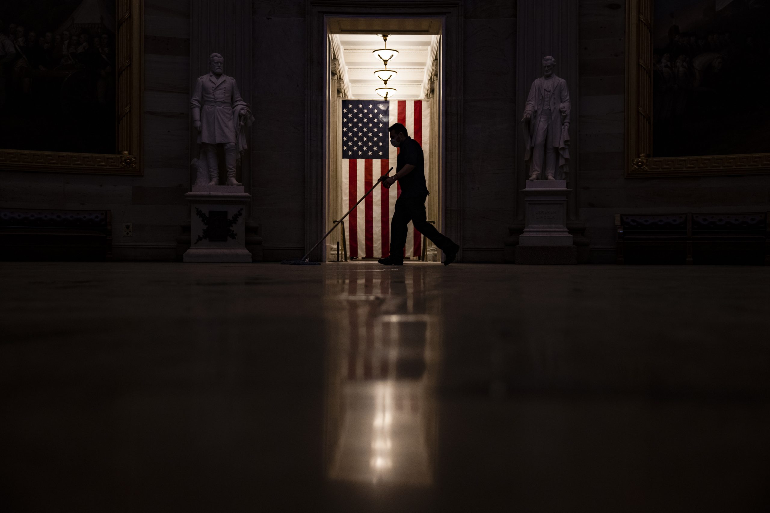 WASHINGTON, DC - JANUARY 07: A worker sweeps up the dust and debris that was left behind by a pro-Trump mob in the Rotunda of the U.S. Capitol building on January 7, 2021 in Washington, DC. Following a rally yesterday with President Donald Trump on the National Mall, a pro-Trump mob stormed and broke into the U.S. Capitol building causing a Joint Session of Congress to delay the certification of President-elect Joe Biden's victory over President Trump. (Photo by Samuel Corum/Getty Images)
