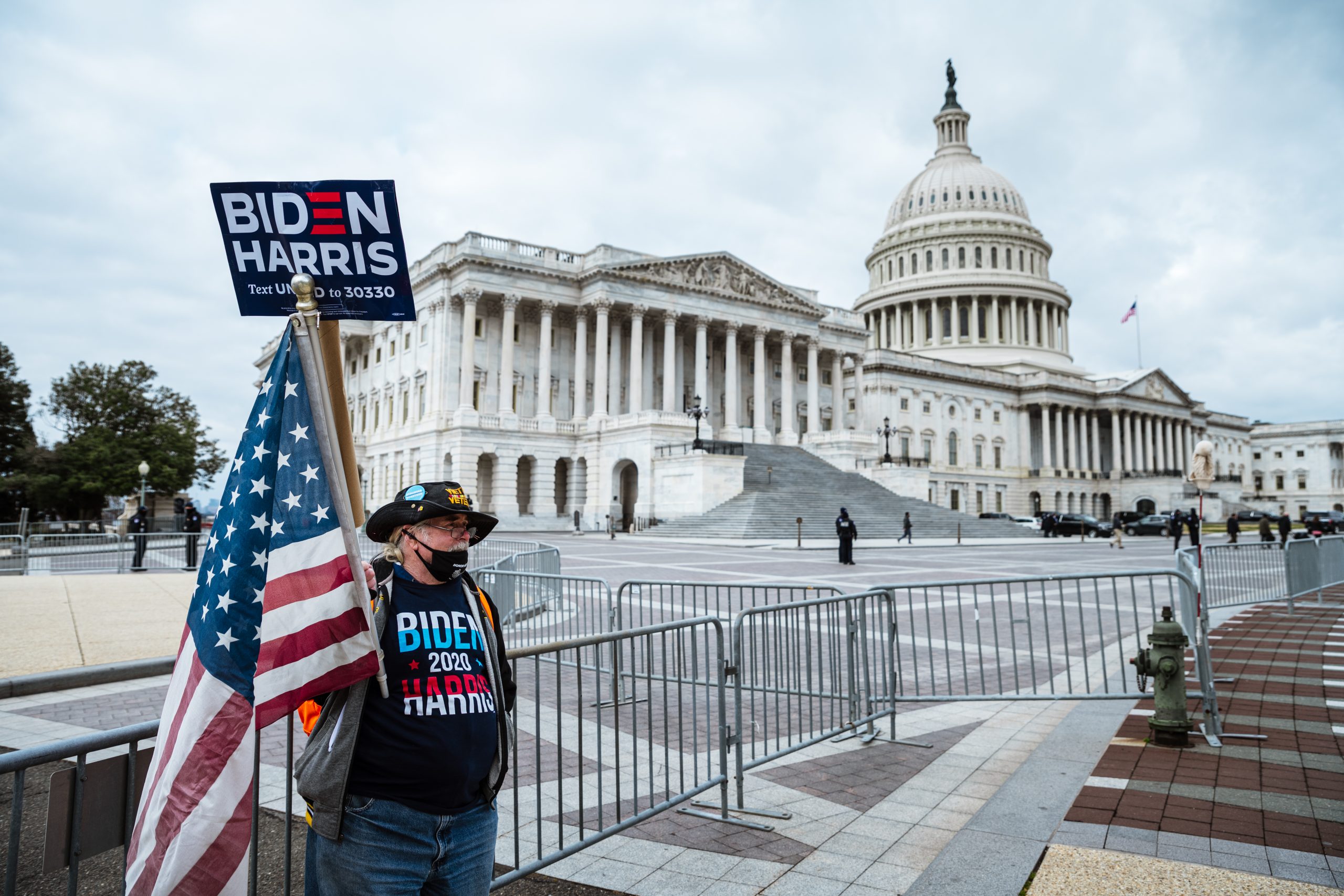 WASHINGTON, DC - JANUARY 06: A counter-protester in holding a sign in support of President-elect Joe Biden and vice-president-elect Kamala Harris stands before Capitol Building on January 6, 2021 in Washington, DC. A pro-Trump mob stormed the Capitol, breaking windows and clashing with police officers. Trump supporters gathered in the nation's capital today to protest the ratification of President-elect Joe Biden's Electoral College victory over President Trump in the 2020 election. (Photo by Jon Cherry/Getty Images)