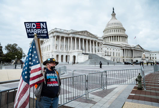 WASHINGTON, DC - JANUARY 06: A counter-protester in holding a sign in support of President-elect Joe Biden and vice-president-elect Kamala Harris stands before Capitol Building on January 6, 2021 in Washington, DC. A pro-Trump mob stormed the Capitol, breaking windows and clashing with police officers. Trump supporters gathered in the nation's capital today to protest the ratification of President-elect Joe Biden's Electoral College victory over President Trump in the 2020 election. (Photo by Jon Cherry/Getty Images)
