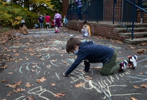 STAMFORD, CONNECTICUT - OCTOBER 21: A first grader draws during recess at Stark Elementary School on October 21, 2020 in Stamford, Connecticut. Stamford Public Schools is continuing the fall semester with a hybrid model of in-class and distance learning, occasionally quarantining individual classes when a student or faculty member tests positive for COVID-19.  (Photo by John Moore/Getty Images)