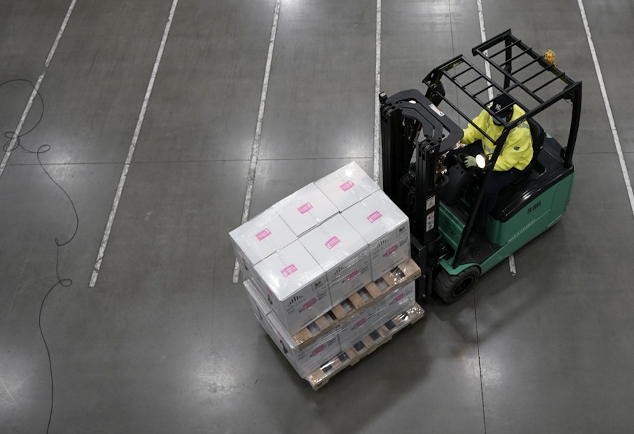 a man driving a forklift with boxes on it