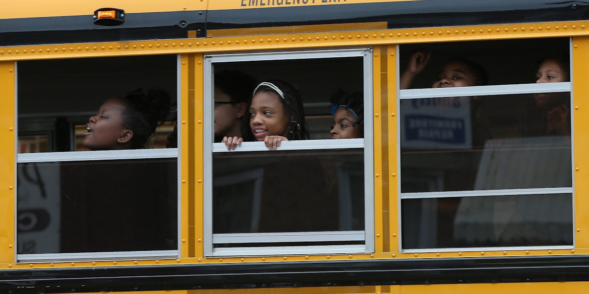 BALTIMORE, MD - MAY 01:  Children riding home from school on a school bus watch as Baltimore residents celebrate at the corner of West North Avenue and Pennsylvania Avenue after Baltimore authorities released a report on the death of Freddie Gray  on May 1, 2015 in Baltimore, Maryland. Marilyn Mosby, Baltimore City State's Attorney, ruled the death of Freddie Gray a homicide and that criminal charges will be filed. Gray, 25, was arrested for possessing a switch blade knife on April 12 outside the Gilmor Houses housing project on Baltimore's west side. According to his attorney, Gray died a week later in the hospital from a severe spinal cord injury he received while in police custody.  (Photo by Win McNamee/Getty Images)