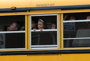 BALTIMORE, MD - MAY 01:  Children riding home from school on a school bus watch as Baltimore residents celebrate at the corner of West North Avenue and Pennsylvania Avenue after Baltimore authorities released a report on the death of Freddie Gray  on May 1, 2015 in Baltimore, Maryland. Marilyn Mosby, Baltimore City State's Attorney, ruled the death of Freddie Gray a homicide and that criminal charges will be filed. Gray, 25, was arrested for possessing a switch blade knife on April 12 outside the Gilmor Houses housing project on Baltimore's west side. According to his attorney, Gray died a week later in the hospital from a severe spinal cord injury he received while in police custody.  (Photo by Win McNamee/Getty Images)