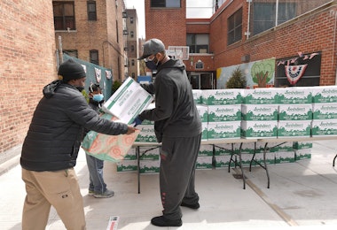 NEW YORK, NEW YORK - APRIL 08: Former professional baseball player CC Sabathia (R) distributes pantry boxes to Boys And Girls Club families at the Belmont Community Day Care Center on April 08, 2020 in The Bronx Borough of New York City. (Photo by Michael Loccisano/Getty Images)