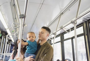 A photograph of a father and son riding the bus.
