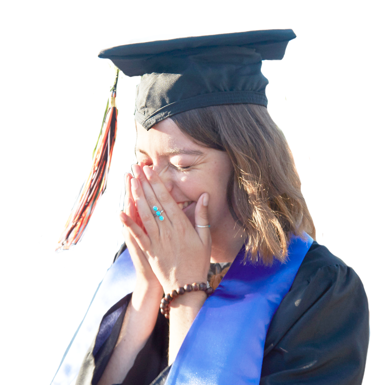 a woman in a cap and gown covers her face with her hands