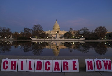 WASHINGTON, DC - DECEMBER 14: Childcare Now is spelled out on signs during Child Care Providers and Parents Rally to Pass Build Back Better at the U.S. Capitol on December 14, 2021 in Washington, DC. 50 years after President Nixon vetoed child care legislation, parents and providers rally to ensure child care is passed through Build Back Better. (Photo by Leigh Vogel/Getty Images for Child Care For Every Family Network)