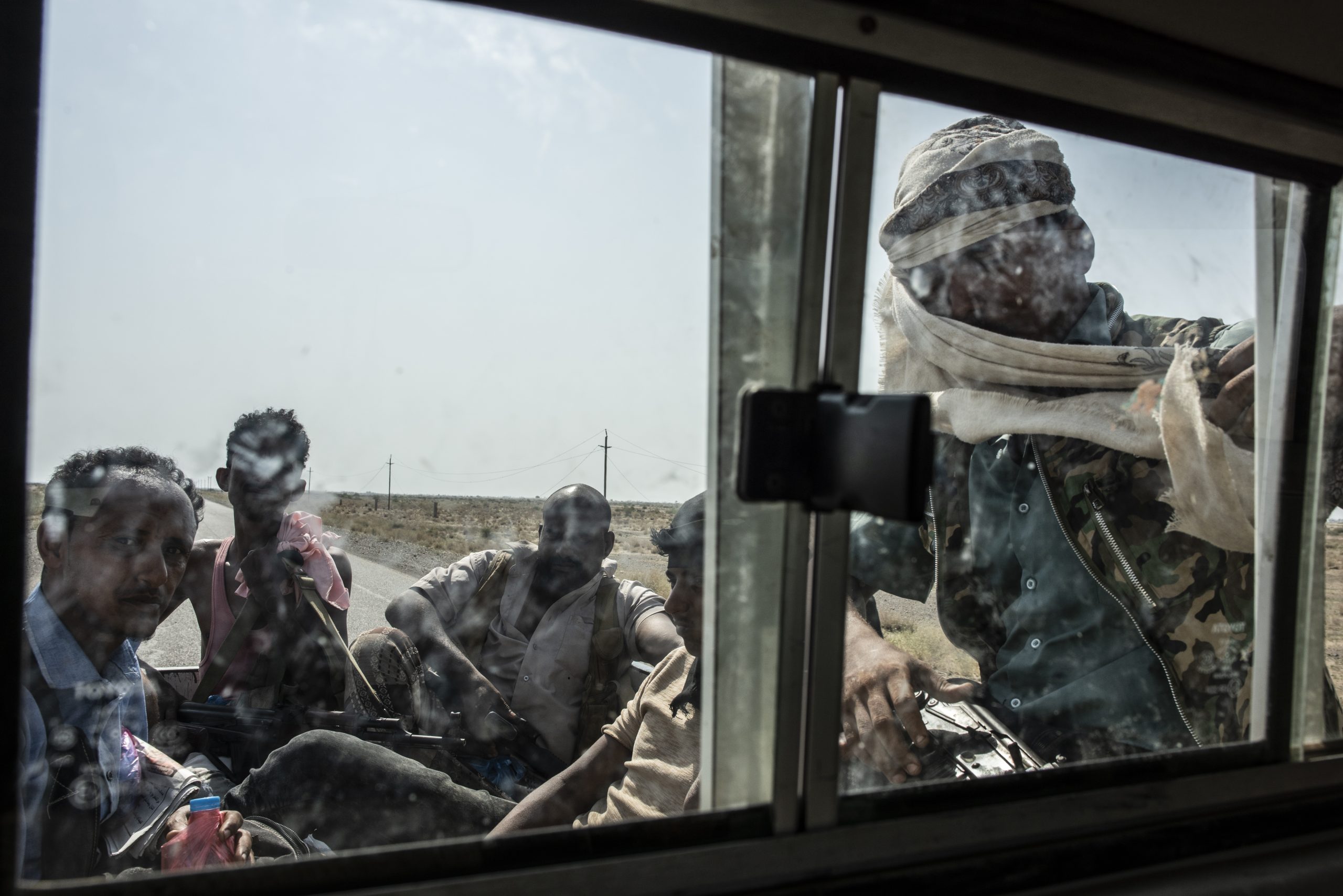 HAIZ, YEMEN - SEPTEMBER 19: Tahami Resistance fighters, a militia aligned with Yemen's Saudi-led coalition-backed government sit in the back of a truck on the way heading to the frontline of fighting on September 19, 2018 in Haiz, Yemen. A coalition military campaign has moved west along Yemen's coast toward Hodeidah, where increasingly bloody battles have killed hundreds since June, putting the country's fragile food supply at risk. (Photo by Andrew Renneisen/Getty Images)